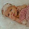 newborn, baby, infant, pink_blanket, headband, pearls, white_lace, soft_texture, lying_down, portrait, cute, small_hands, delicate, peaceful, cozy, sleepy, closeup, baby_clothing, resting, indoors