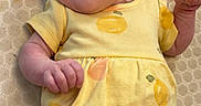 Avery is registered to the contest to win money with this photo: apparel, baby, child, cute, face, hand, happy, headband, infant, infant_fashion, lying_down, patterned_clothing, person, playful, skin, smiling, textured_blanket, tongue_out, yellow_dress, young_child