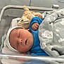 Adam participe au concours pour gagner de l'argent avec cette photo : newborn, baby, sleeping, blanket, blue_clothing, hospital_bassinet, plush_toy, infant, cute, peaceful, face, headwear, swaddled, resting, indoors, soft_toy, cozy, baby_bed, child, newborn_baby