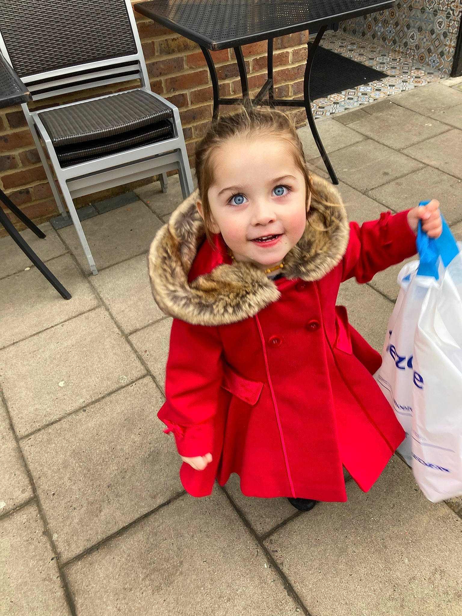 Darcie is registered to the contest to win money with this photo: chair, child, floor, flooring, fun, glove, grass, hairstyle, happy, jacket, joy, leisure, outdoor_furniture, person, plastic_bag, recreation, sitting, smile, toddler, tree