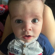 Cameron is registered to the contest to win money with this photo: baby, child, infant, face, eyes, expression, curious, shirt, clothing, sitting, legs, person, portrait, indoors, closeup, cute, young, skin, head, mouth