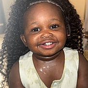 Carolina participe au concours pour gagner de l'argent avec cette photo : baby, black_child, bracelet, child, closeup, clothing, curly_hair, cute, expression, face, happy, indoor, person, portrait, seated, skin, sleeveless_shirt, smiling, toddler, young_child