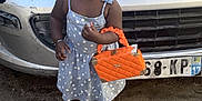 Carolina a rejoint le concours — aidez-le/la à gagner de superbes lots ! car, child, concrete, cute, dress, fashion, front_view, handbag, happy, license_plate, orange, outdoor, person, polka_dot, sandals, silver, smiling, standing, toddler, vehicle