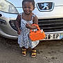 Carolina a rejoint le concours — aidez-le/la à gagner de superbes lots ! asphalt, car, child, cute, daylight, fashion, front_view, happy, license_plate, orange_purse, outdoor, person, polka_dot_dress, portrait, sandals, small_bag, smiling, standing, toddler, vehicle