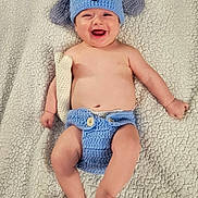 Will joined the competition — help win amazing prizes! baby, infant, child, smiling, laughing, portrait, lying_down, knitted_hat, dog_hat, blue_clothing, diaper_cover, blanket, cozy, indoor, happy, playful, crocheted_toy, barefoot, close_up, adorable