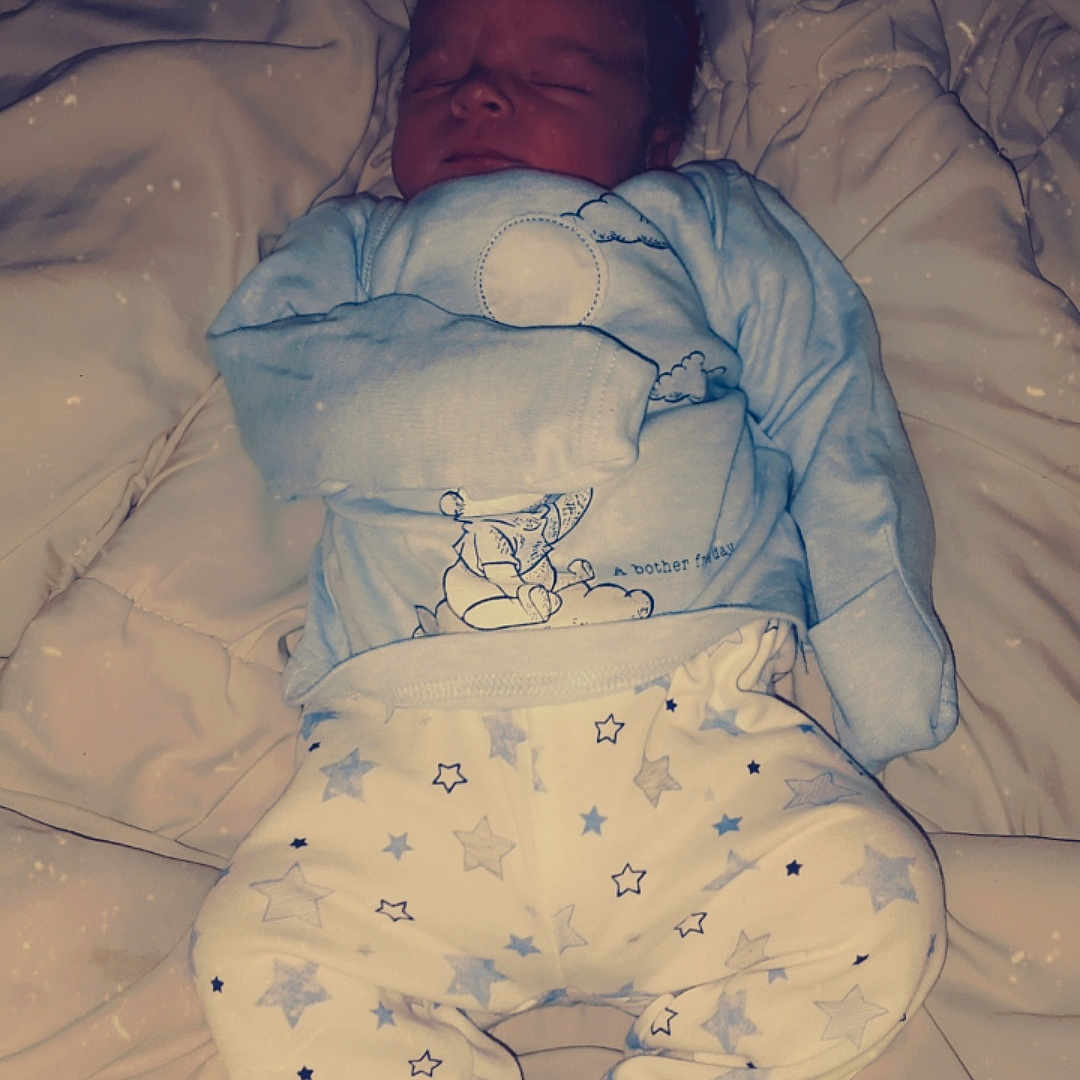 Jacob is registered to the contest to win money with this photo: baby, bed, bedroom, blanket, clothing, couch, cradle, crib, face, furniture, glove, head, indoors, infantbed, newborn, person, photography, portrait, room, sleeping