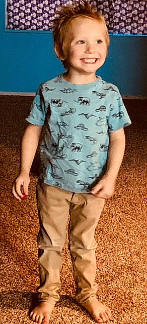 Sebastian is registered to the contest to win money with this photo: camouflage, child, cool, denim, fun, gesture, happy, joint, joy, military_camouflage, pattern, person, sleeve, smile, standing, t_shirt, textile, thigh, toddler, trunk