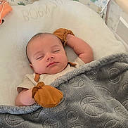 Nathan joined the competition — help win amazing prizes! baby, sleeping, mittens, blanket, bassinet, dinosaur_pattern, indoor, cozy, infant, face, resting, soft_texture, child, cute, peaceful, nursery, home, comfort, blanket_pattern, infant_clothing