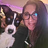 Harley Quinn is registered to the contest to win money with this photo: woman, puppy, dog, selfie, portrait, glasses, smiling, pet, cuddling, indoor, bedroom, led_lights, purple_lighting, black_and_white, brown_fur, blue_eyes, close_up, long_hair, nose_ring, cozy