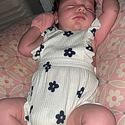 Hazel is registered to the contest to win money with this photo: baby, sleeping, onesie, flower_pattern, pink, cushion, mittens, infant, cute, peaceful, child, indoor, soft, resting, portrait, skin, face, chubby, newborn, relaxed