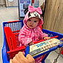baby, child, shopping_cart, pink_clothing, hoodie, minnie_mouse, indoor, supermarket, person, hand, floor, tile, blue, red, toy, face, cute, clothing, baby_girl, winter_wear
