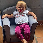 Léna a rejoint le concours — aidez-le/la à gagner de superbes lots ! toddler, child, pacifier, purple_leggings, white_tshirt, armchair, indoor, tile_floor, relaxed, smiling, blond_hair, furniture, person, casual, seated, small_chair, cute, baby, home, portrait