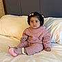 toddler, child, pink_outfit, bed, white_bedspread, hair_clip, pink_shoes, indoors, portrait, cute, cozy_clothing, sitting, young_child, person, soft_lighting, neutral_background, expression, baby, candid, comfortable
