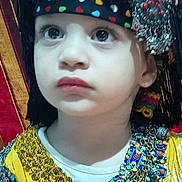 Tindaya a rejoint le concours — aidez-le/la à gagner de superbes lots ! child, face, headwear, jewelry, traditional_clothing, colorful, portrait, young, expression, beads, tassels, fabric, closeup, costume, cultural, decorative, patterned, indoors, serious, accessory