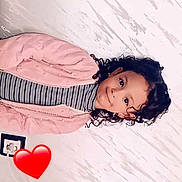Anel a rejoint le concours — aidez-le/la à gagner de superbes lots ! child, curly_hair, smile, striped_clothing, pink_jacket, turtleneck, indoor, wall, texture, portrait, face, person, cute, young, emotion, cozy, happy, heart_emoji, photography, casual