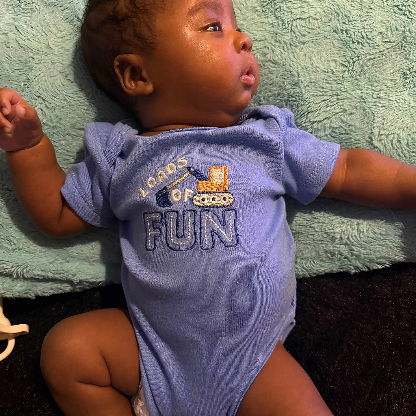 Asad joined the competition — help win amazing prizes! baby, infant, blue_onesie, sock, lying_down, soft_blanket, embroidery, side_profile, cute, child, skin, hand, leg, head, clothing, expression, indoors, toddler, person, newborn