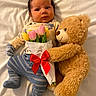 Roman is registered to the contest to win money with this photo: baby, teddy_bear, tulips, bouquet, red_bow, striped_pants, mittens, white_sheet, cute, infant, soft_toy, lying_down, flower_bouquet, plush, child, portrait, smiling, indoors, cozy, adorable