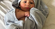 Roman is registered to the contest to win money with this photo: baby, towel, infant, bed, blanket, wrapped, skin, feet, face, head, lying_down, cute, soft, child, newborn, indoors, comfort, rest, sleepy, portrait