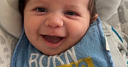 Roman is registered to the contest to win money with this photo: baby, baby_seat, bib, cheerful, child, closeup, clothing, cute, expression, face, happy, indoors, infant, joyful, mohawk, pattern, person, smile, straps, young
