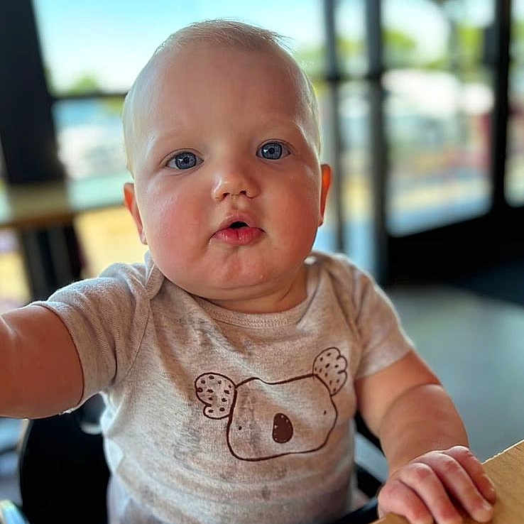 Tobias is registered to the contest to win money with this photo: arm, baby, bodypart, clothing, computerhardware, electronics, face, finger, hand, hardware, head, mobilephone, monitor, person, phone, photography, portrait, screen, sitting, t_shirt