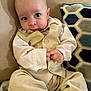 Jaxson joined the competition — help win amazing prizes! baby, infant, child, couch, pillow, beige_clothing, vest, pants, sitting, indoor, curious, hands, face, eyes, soft_furniture, home, portrait, cute, young, person