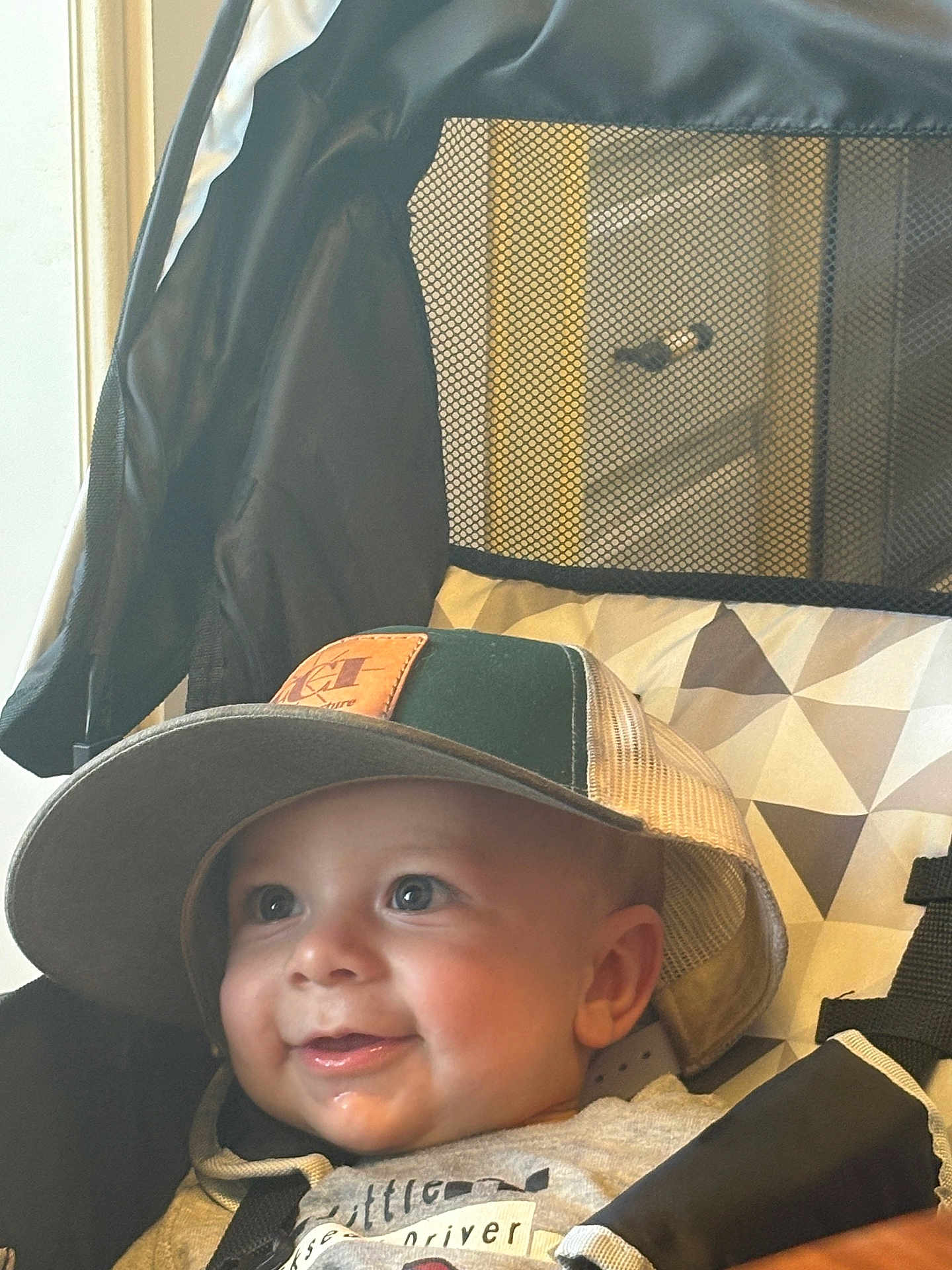 Jaxson joined the competition — help win amazing prizes! baby, child, cap, hat, smile, happy, stroller, mesh, face, clothing, infant, cheek, eyes, cute, seatbelt, fabric, indoor, person, headwear, portrait