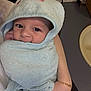 Jaxson is registered to the contest to win money with this photo: baby, towel, hood, face, eyes, hand, arm, bracelet, person, indoor, bathroom, sink, cabinet, skin, cute, child, expression, holding, blue, textile