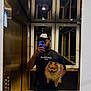 man, dog, pom, mirror, selfie, elevator, gold, marble, cap, tshirt, phone, reflection, smile, pet, indoor, casual, portrait, holding, happy, lighting