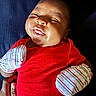 Xzayvion is registered to the contest to win money with this photo: baby, infant, red_clothing, mittens, smiling, face, hand, lying_down, texture, striped, person, child, cute, happy, skin, newborn, portrait, apparel, resting, closeup