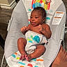 Xzayvion is registered to the contest to win money with this photo: baby, infant, baby_seat, floor, foot, animal_print, colorful, wooden_floor, cute, child, playful_expression, indoors, small, sitting, comfort, toddler, person, skin, human, relaxing