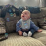 Thomas joined the competition — help win amazing prizes! baby, child, bubbles, couch, striped, window, curtains, light, indoor, blue_clothing, bib, socks, seated, happy, face, hand, expression, soft_fabric, home, cozy