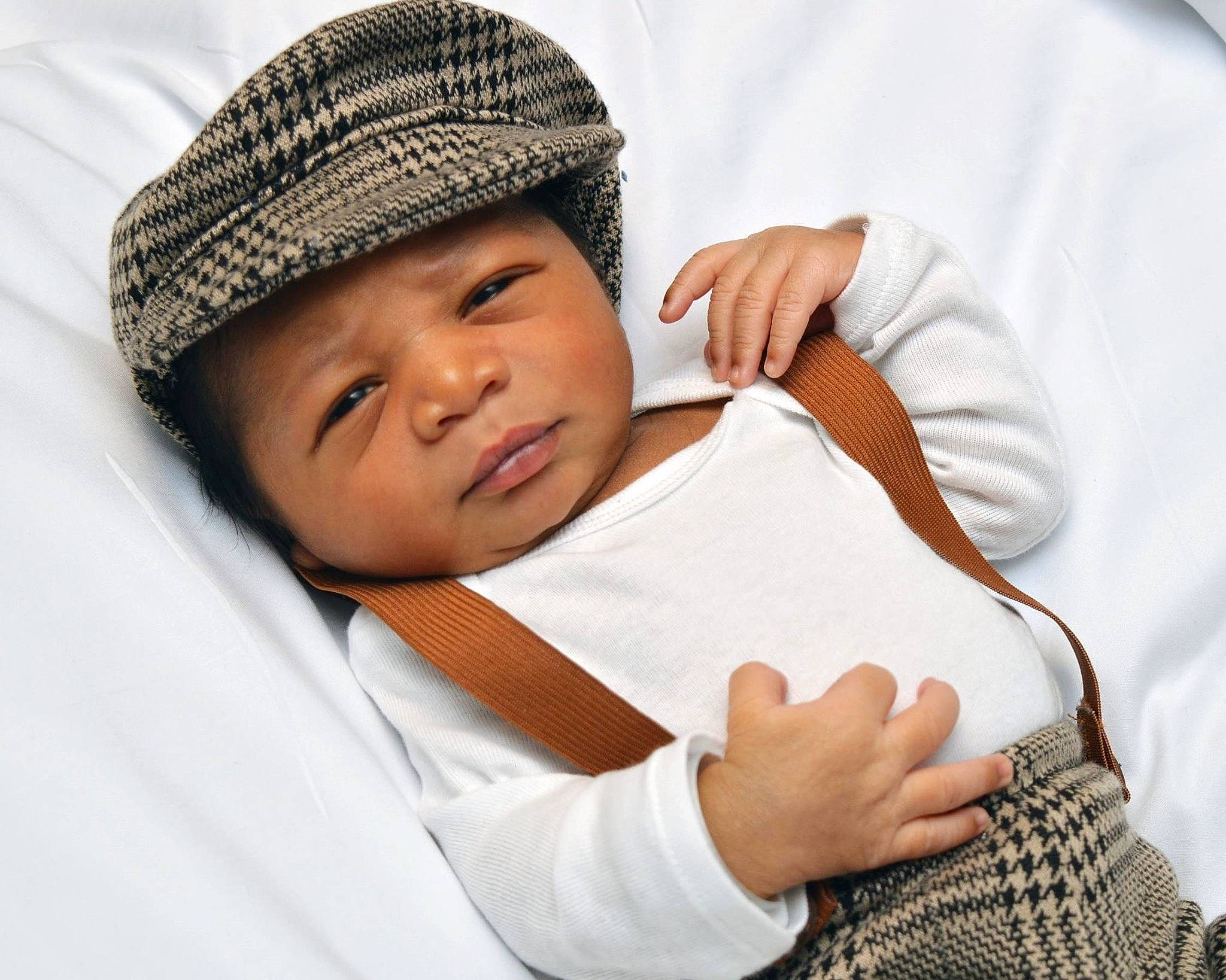 Channing is registered to the contest to win money with this photo: baby, beanie, bonnet, cap, child, comfort, eye, gesture, happy, headwear, knit_cap, pattern, person, portrait_photography, room, sitting, skin, sleeve, thumb, toddler