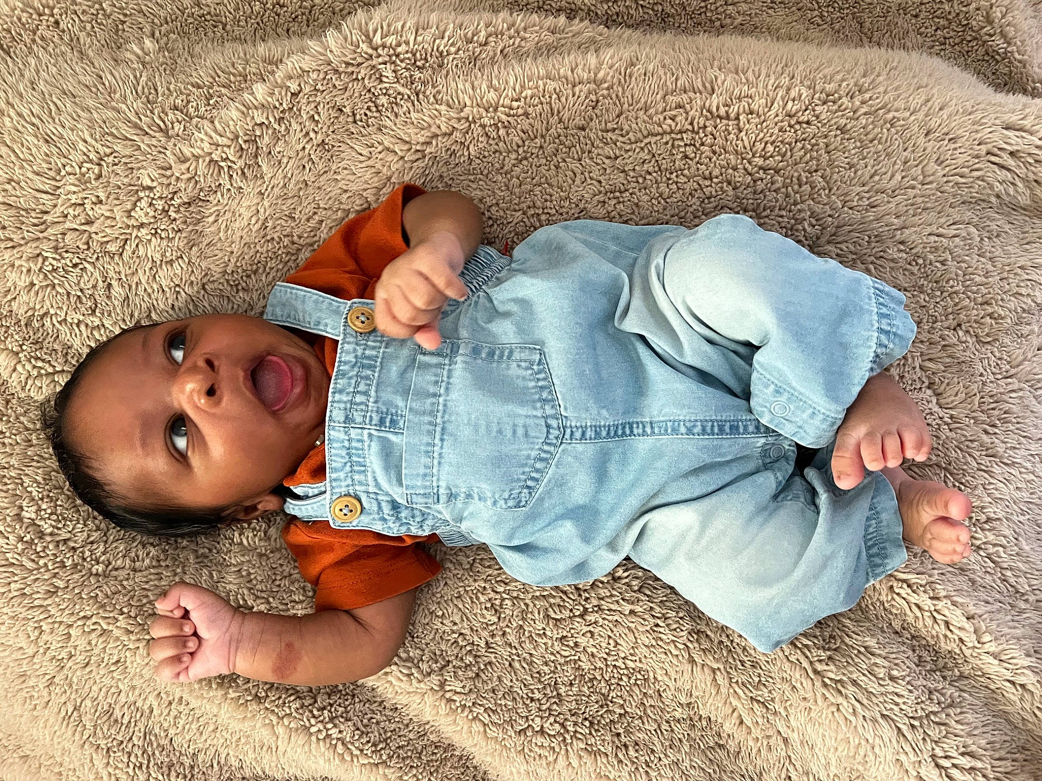 Channing is registered to the contest to win money with this photo: arm, baby, baby_toddler_clothing, child, comfort, finger, flooring, grass, hand, human, human_body, leaf, leg, nose, person, sitting, skin, sleeve, surprise, textile