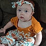 baby, child, infant, headband, pumpkin, orange_clothing, pants, sitting, couch, indoor, curious, wide_eyes, cute, toes, autumn_theme, soft_lighting, portrait, person, young, cozy