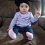Willow is registered to the contest to win money with this photo: baby, child, sitting, chair, cushion, clothing, headband, bow, socks, pants, sweater, face, person, indoor, cute, young_child, blue_eyes, expressionless, soft_furniture, portrait