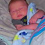 Eli is registered to the contest to win money with this photo: baby, blanket, sleeping, infant, soft, cute, cozy, face, child, rest, peaceful, furniture, clothing, hand, head, portrait, indoors, comfort, toddler, wrapped