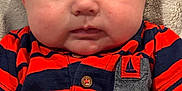 Eli is registered to the contest to win money with this photo: baby, infant, face, chubby_cheeks, curious, red_shirt, striped_shirt, pocket, sailboat_emblem, short_sleeves, texture, closeup, portrait, cute, child, skin, eyes, expression, casual_clothing, indoors