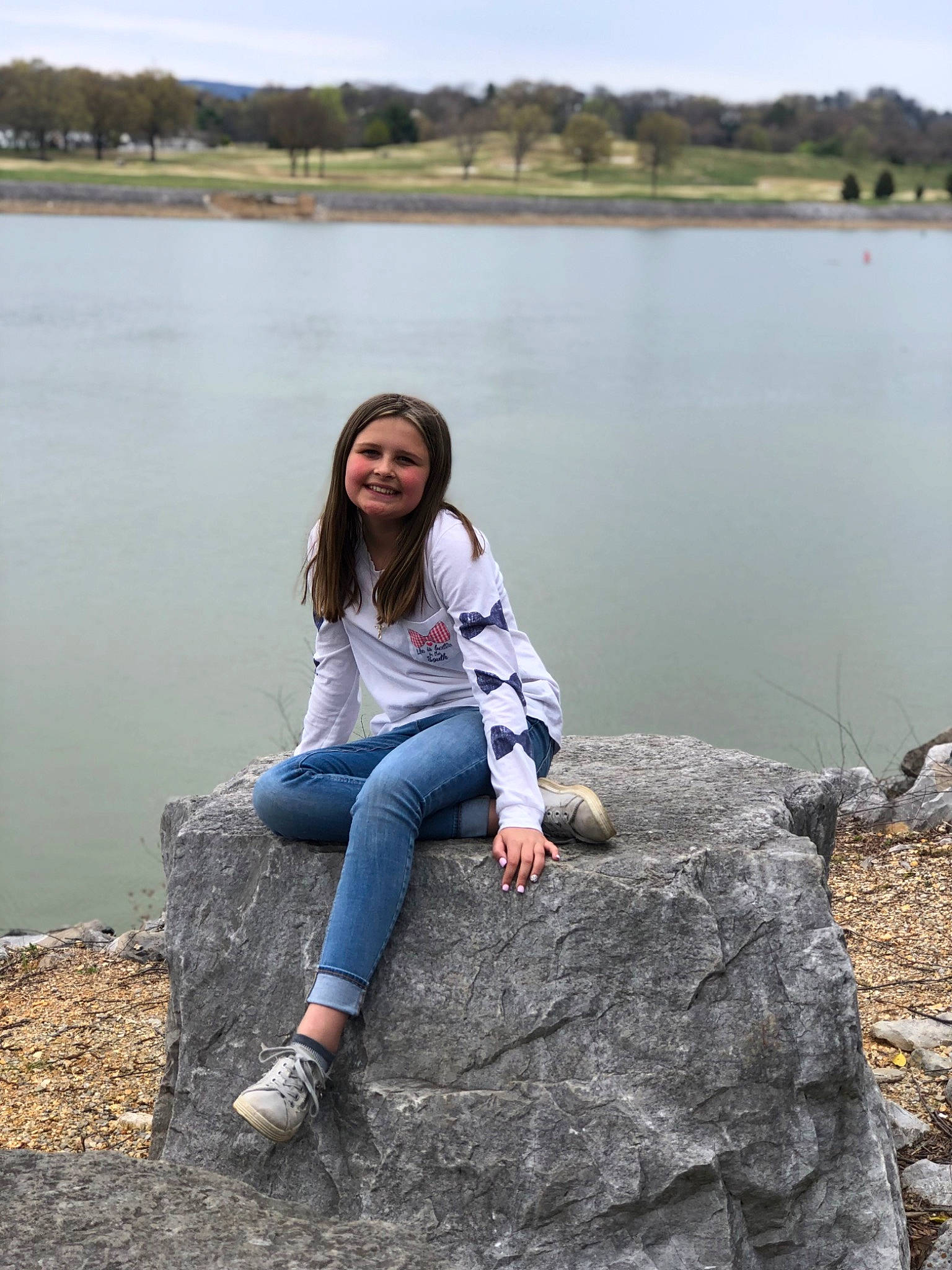 Kimberly is registered to the contest to win money with this photo: bank, flash_photography, grass, hair, happy, joy, lake, landscape, leaf, leg, leisure, nature, people_in_nature, person, shoe, sky, smile, sneakers, standing, travel