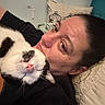 Tux joined the competition — help win amazing prizes! black_and_white_cat, black_shirt, casual, cat, close_up, comfort, couch, cozy, fur, home, human_face, indoor, person, pet, pillow, relaxed, resting, sleeping_cat, snuggling, whiskers