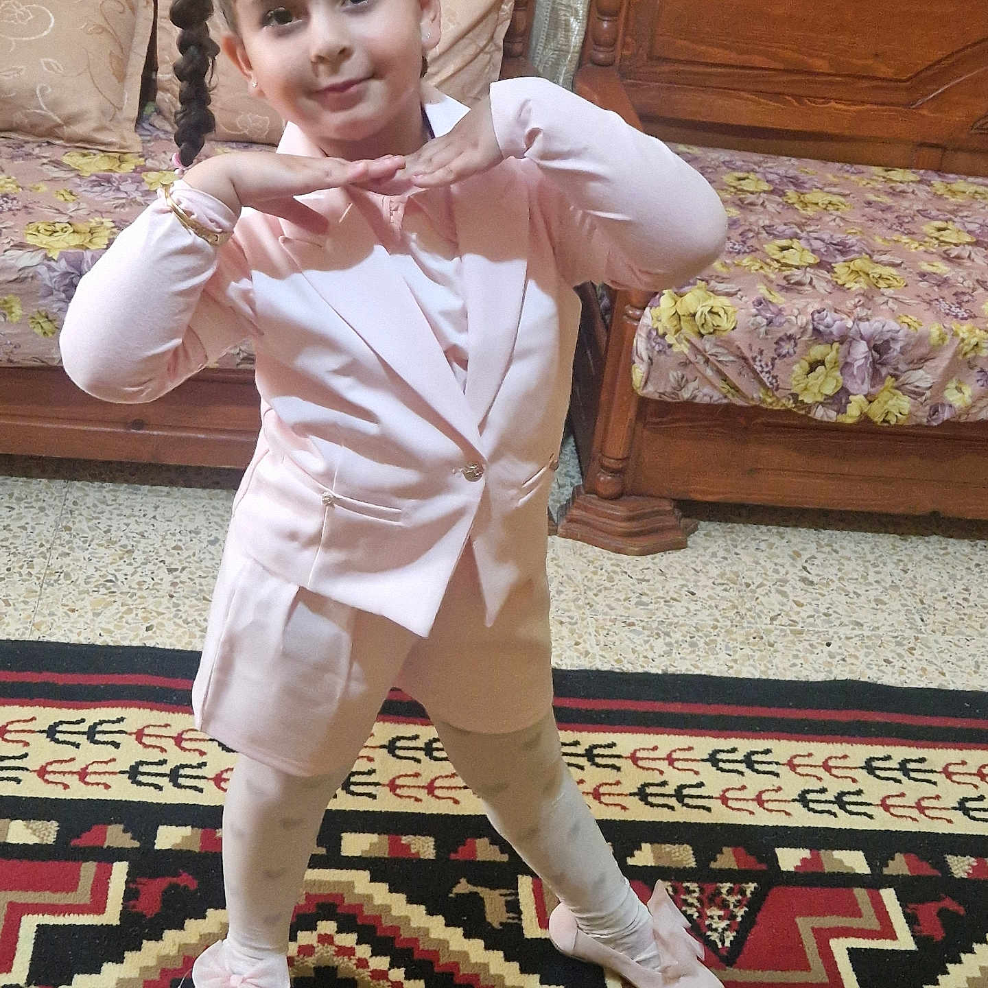Mady participe au concours pour gagner de l'argent avec cette photo : child, girl, pink_clothing, posing, smiling, indoor, carpet, wooden_furniture, bed, floral_bedspread, braided_hair, leggings, shoes, bracelet, earrings, cute, playful, home, portrait, person
