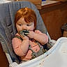 toddler, high_chair, red_hair, messy, food, blue_food, kitchen, snacks, boxes, pepsi, wafers, child, curious, pink_clothing, indoor, face, hands, seat, table, eating