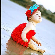 Camila joined the competition — help win amazing prizes! baby, child, red_dress, headband, feathers, beach, sand, water, sitting, cute, portrait, outdoor, infant, funny_face, pouting, photography_watermark, nature, holiday, summer, playful