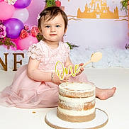 Niraya joined the competition — help win amazing prizes! baby, child, girl, birthday, cake, pink_dress, wooden_spoon, balloons, flowers, decorations, first_birthday, smiling, portrait, celebration, indoors, fairy_tale, castle_backdrop, sitting, cute, festive
