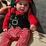 Fares Naël a rejoint le concours — aidez-le/la à gagner de superbes lots ! baby, child, elf_costume, christmas, holiday, red, green, striped_pants, hat, cute, indoors, couch, blanket, smiling, person, infant, seated, hand, soft_toys, cozy