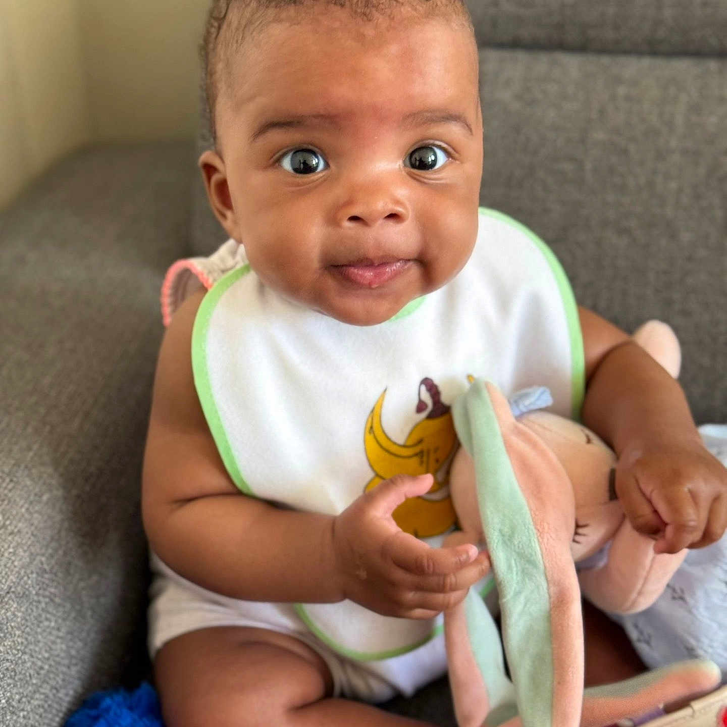 Julianne Kaëla a rejoint le concours — aidez-le/la à gagner de superbes lots ! baby, bib, child, clothing, couch, cute, footwear, hand, happy, home, indoor, infant, person, plush, seated, skin, smiling, soft_toy, stuffed_toy, toddler