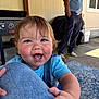 Jaymin joined the competition — help win amazing prizes! baby, child, smiling, happy, face, hand, jeans, blue_shirt, outdoor, patio, adult, person, grill, carpet, window, building, daylight, clothing, skin, expression