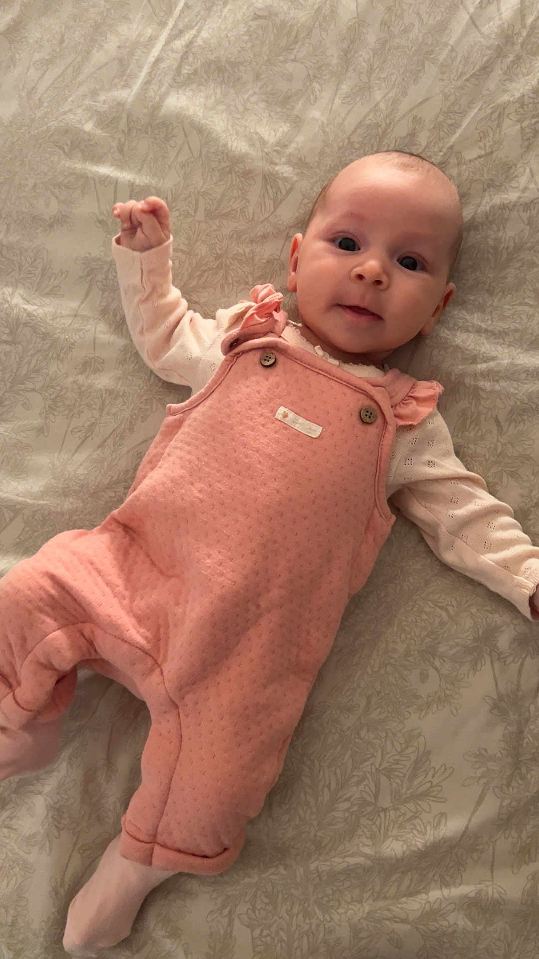 Alessia Canzonieri participe au concours pour gagner de l'argent avec cette photo : baby, infant, pink_overall, white_shirt, bedspread, patterned_bedspread, lying_down, cute, child, face, expression, cozy_clothing, footed_pants, small_hands, indoor, portrait, looking_at_camera, soft_light, human, young_child