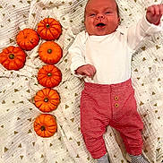 Dominic is registered to the contest to win money with this photo: baby, babylaughing, clothing, face, food, happy, head, hosiery, leaf, pants, person, photography, plant, portrait, produce, pumpkin, sock, squash, vegetable, yawning
