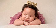 Milana is registered to the contest to win money with this photo: baby, infant, crown, curly_hair, sleeping, pink_ruffles, soft_background, resting, peaceful, portrait, cute, newborn, child, skin, face, hands, cozy, closeup, adorable, headwear