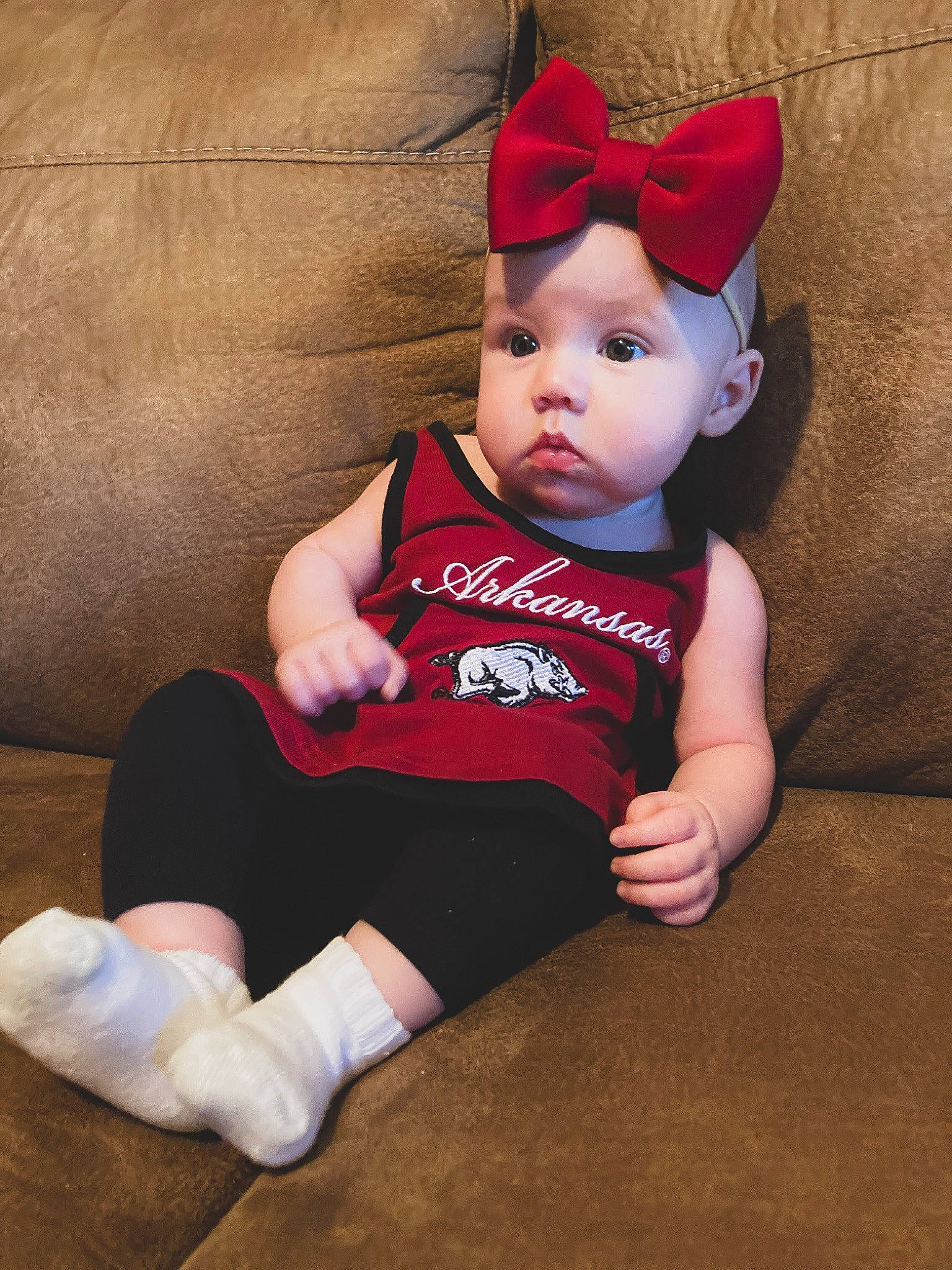 Mia Reece is registered to the contest to win money with this photo: baby, baby_toddler_clothing, comfort, costume_hat, eye, face, finger, happy, hat, head, human_body, human_leg, knee, lap, leg, person, sleeve, sock, t_shirt, thigh